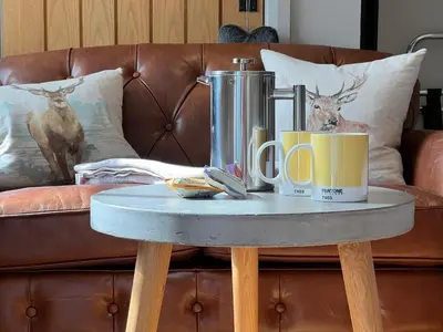 a table with two coffee mugs on top of a couch at Nether Glenny Farm in Stirling