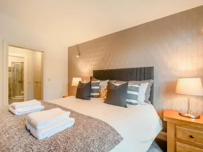 a bedroom with a large bed with towels on it at The Buckie at Buchanan - Drymen Holiday Home Sleeps 8 in Drymen