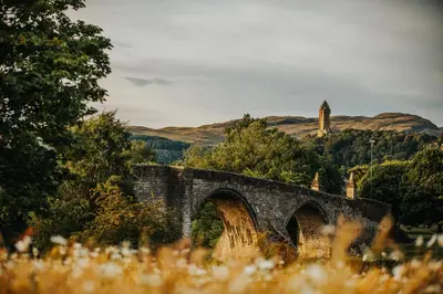 an old stone bridge with a tower in the background at The Buckie at Buchanan - Drymen Holiday Home Sleeps 8 in Drymen