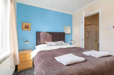 a bedroom with a large bed with two towels on it at NEW Four Bedroom House - all rooms ensuite in Stirling