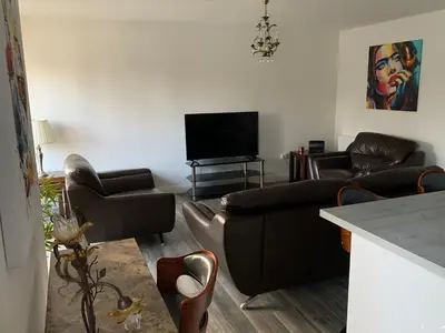 a living room with couches and a flat screen tv at Tanllan Apartment in Callander
