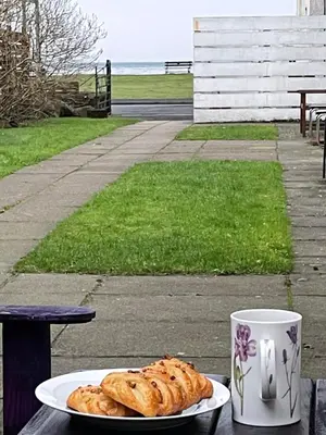 a plate of pastries on a table next to a cup at Lamlash (holiday) Lets in Lamlash