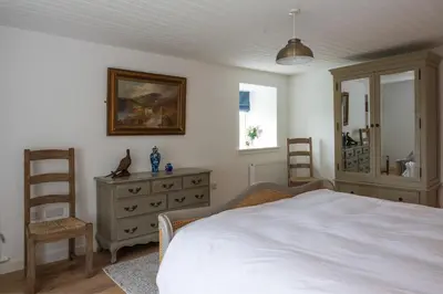 a bedroom with a white bed and a dresser at Laverockbank Farmhouse in Perth