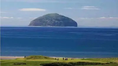 a group of people standing in front of an island in the ocean at AJL Caravan Rentals in Turnberry