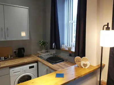 a kitchen with a sink and a washing machine at One bedroom flat, very close to Town center. in Oban