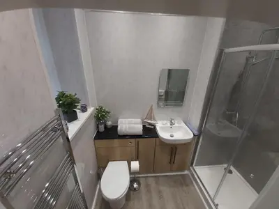 a bathroom with a sink and a shower and a toilet at One bedroom flat, very close to Town center. in Oban
