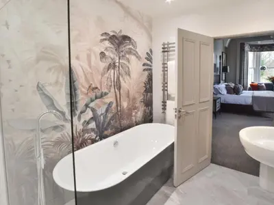 a bathroom with a tub and a sink at The Meadowpark Bar, Kitchen & Rooms in Stirling