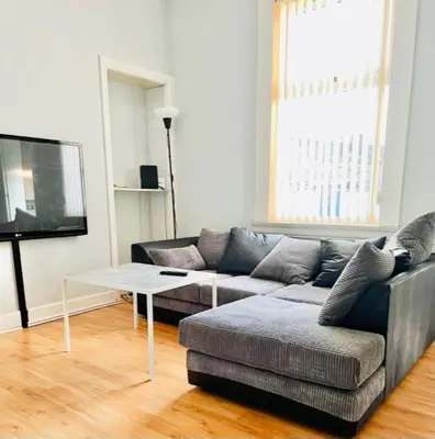 a living room with a couch and a table at Gardiner Cottage in Prestwick