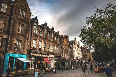 a city street with buildings and people walking down a street at Charming Grassmarket 1 Bed Castle pad in Edinburgh