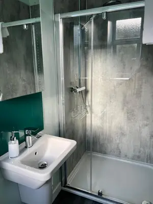 a bathroom with a sink and a glass shower at Killorn Guest House in Oban