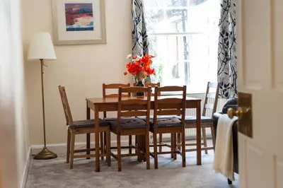 a dining room with a table and chairs and a window at Lovely 3 bed apartment in central Edinburgh in Edinburgh