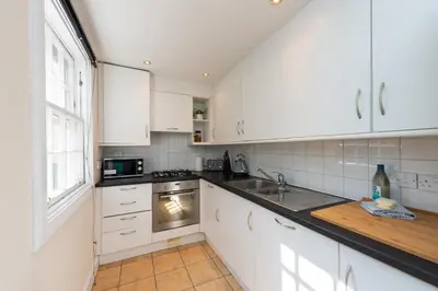 a kitchen with white cabinets and a stove top oven at Lovely 3 bed apartment in central Edinburgh in Edinburgh