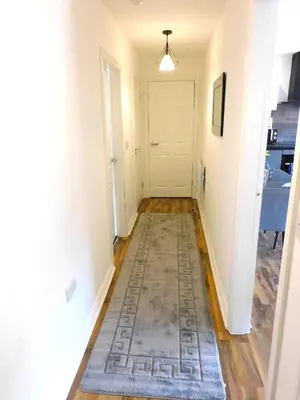 a hallway with a rug and a white door at Newly refurbished 1 bed Apt in Hamilton Close to station and local amenities in Hamilton