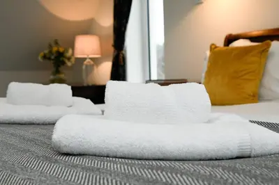 two stacks of towels sitting on top of a bed at Blackmount House in Oban