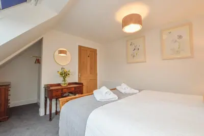 a bedroom with two beds and a table with a drawer at Blackmount House in Oban