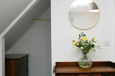 a vase of flowers on a table with a mirror at Blackmount House in Oban