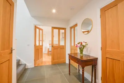 a hallway with a table and a vase of flowers on it at Blackmount House in Oban