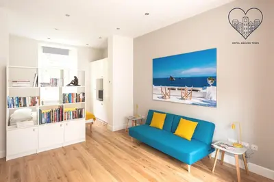 a living room with a blue couch and a book shelf at Artist's Studio in Stockbridge in Edinburgh