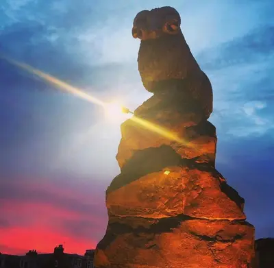 a statue of a bear sitting on top of a rock at Moffat House in Moffat