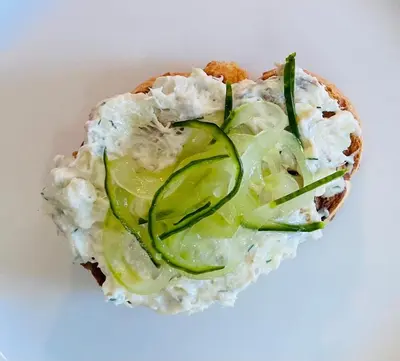 a sandwich with pickles on it on a white plate at Moffat House in Moffat