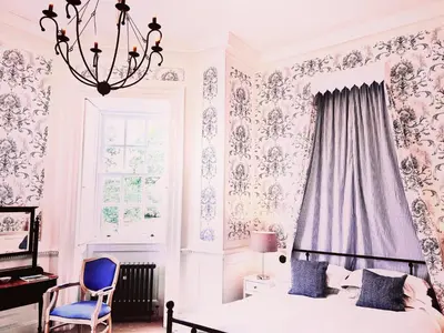 a bedroom with a bed and a chair and a chandelier at Moffat House in Moffat