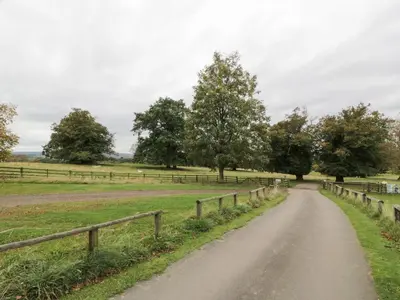a dirt road in a field with trees at Gate Lodge, House of Binns in Linlithgow