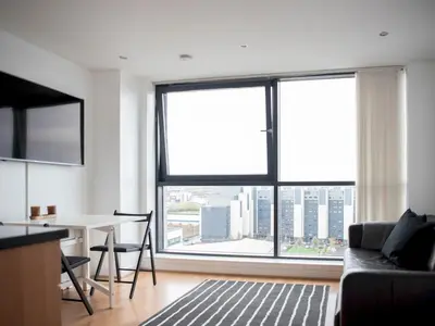 a living room with a table and a large window at Cosy 1 bed next to SEC, OVO Hydro, Finnieston - Pass the Keys in Glasgow