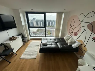 a living room with a couch and a large window at Cosy 1 bed next to SEC, OVO Hydro, Finnieston - Pass the Keys in Glasgow