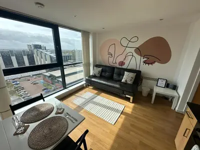 a living room with a couch and a large window at Cosy 1 bed next to SEC, OVO Hydro, Finnieston - Pass the Keys in Glasgow