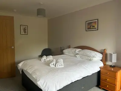 a bedroom with a bed with towels on it at Lyn leven cottages in Ballachulish