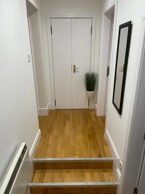 a hallway with a white door and a plant at Heart of George Street 2 in Oban