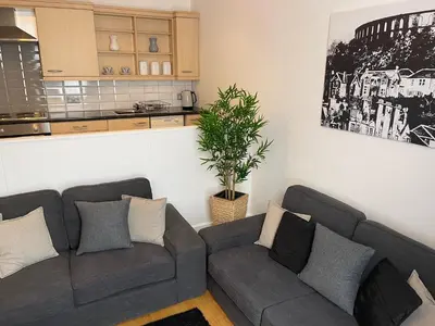 a living room with a couch and a kitchen at Heart of George Street 2 in Oban