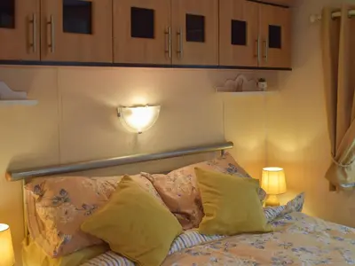 a bedroom with a bed with a light on the wall at Tranquillity Lodge in Annbank