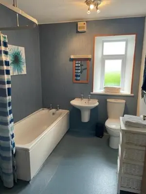 a bathroom with a tub and a toilet and a sink at AIRDSIDE COTTAGE in Castle Douglas