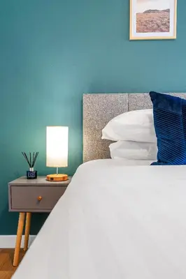 a bedroom with a white bed and a blue wall at Cheerful Stays - Livingston - 4 Bedroom 3 Bath home in Livingston