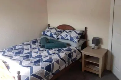 a bedroom with a bed with blue and white at Loch Views Apartment Sleeps 2-Pets Ok-Free Parking in Campbeltown
