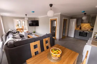 a living room with a couch and a table with a bowl of fruit at Westertonhill Lodges - Private Hot Tub Hire Available in Balloch