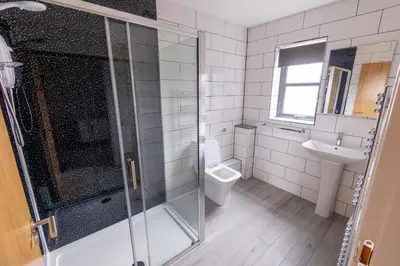 a bathroom with a shower and a toilet and a sink at Westertonhill Lodges - Private Hot Tub Hire Available in Balloch