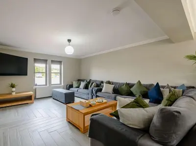 a living room with a couch and a tv at Westertonhill Lodges - Private Hot Tub Hire Available in Balloch