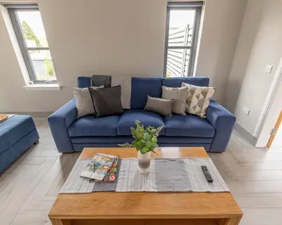 a blue couch in a living room with a coffee table at Westertonhill Holiday Lodges - Private Hot Tub Hire Available in Balloch