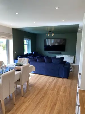 a living room with a blue couch and a table at No 2 The Cairns, Unwind in Style in Oban