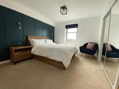 a bedroom with a bed and a blue wall at No 2 The Cairns, Unwind in Style in Oban
