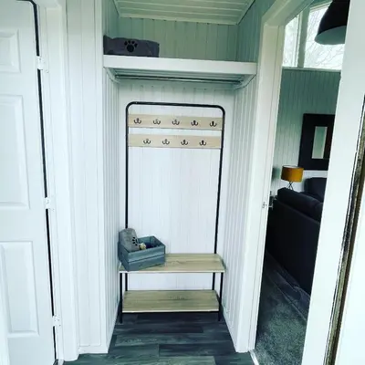 a hallway with a bench in a room with a bed at Cherry tree Lodge in Dunoon