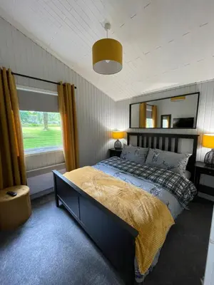 a bedroom with a bed and a large mirror at Cherry tree Lodge in Dunoon