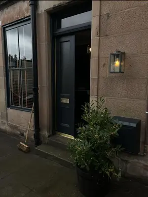 a black door of a building with a potted plant at The Wee Shop, Stylish Two Bed Flat in Inverkip Village in Inverkip
