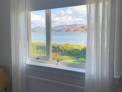 a window with a view of the water at Taigh An Uillt in Tighnabruaich
