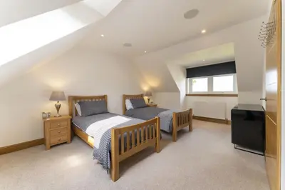 a bedroom with two beds and a television at Higginsneuk in Airth