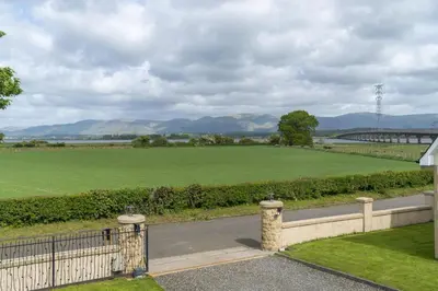 a view of a field and a road with a fence at Higginsneuk in Airth
