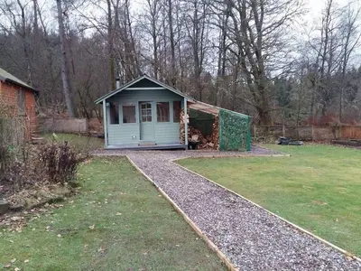 a small shed sitting in a yard with a grass yard at Pinetree Cottage, dog friendly, Holiday let, Callander Invertrossachs in Callander