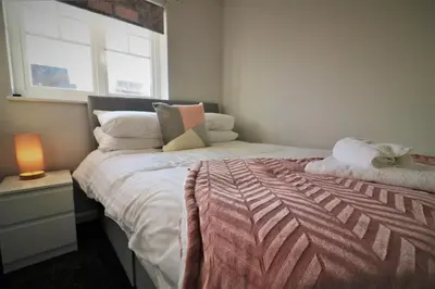 a small bedroom with a bed and a window at Signature - Chapelhall House in Chapelhall